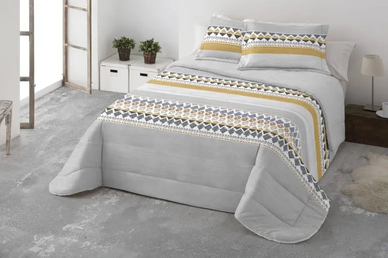 O Edredão de Borrego Bauru é uma peça de roupa de cama que oferece um toque macio e calor envolvente para noites perfeitas. O seu design combina estilo e conforto de uma forma excepcional. O fundo cinza suave proporciona uma base elegante e neutra, criando uma sensação de calma e serenidade no ambiente. As duas faixas de losangos estampadas no edredão, bem como em cada almofada, apresentam uma paleta de cores que vai de tons acinzentados a tons de amarelo torrado, formando um padrão geométrico cativante