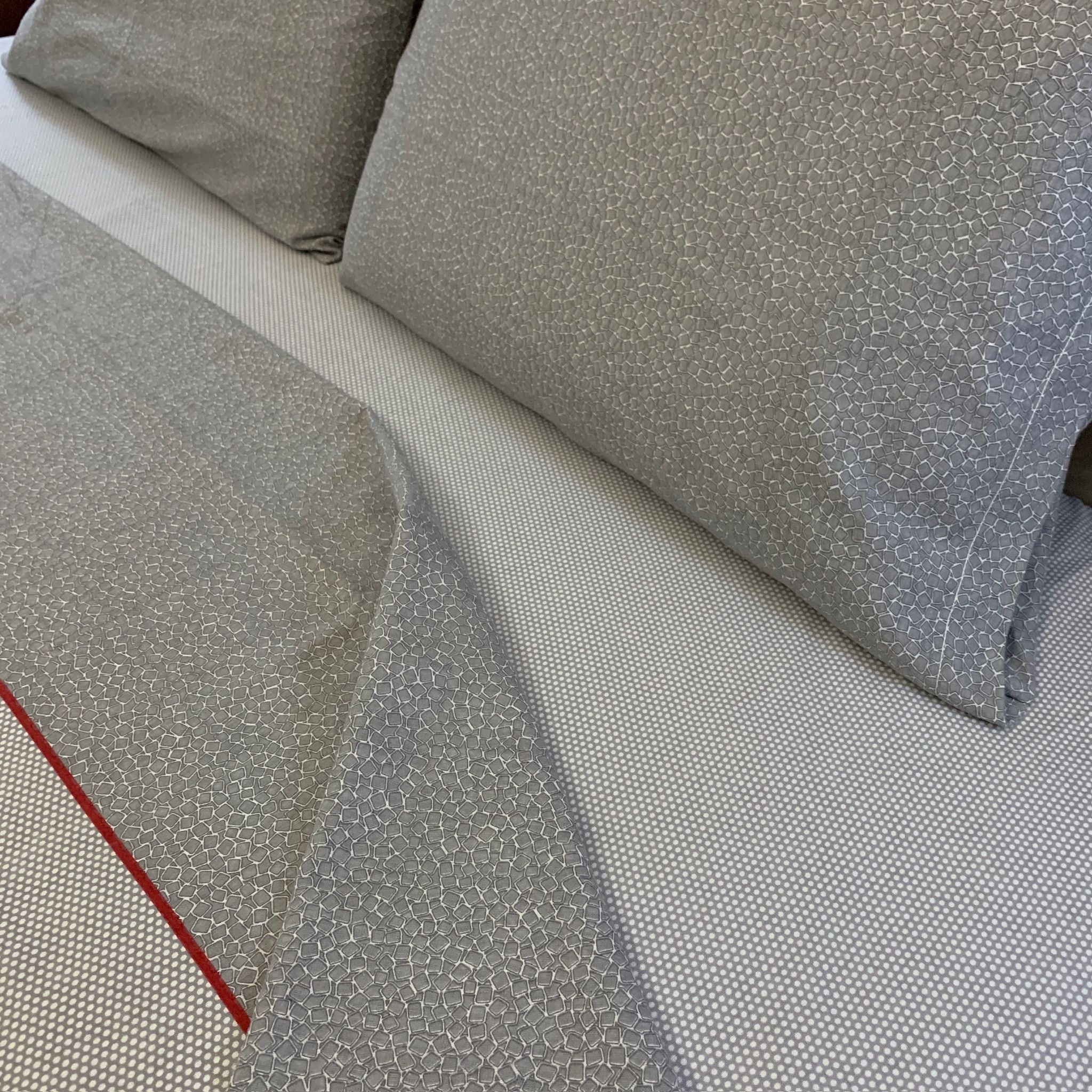 Os lençóis possuem um padrão de mosaicos e uma faixa de bolinhas, oferecendo uma estética elegante e um toque suave devido à flanela de algodão premium. Eles prometem sono de qualidade, durabilidade e um estilo sofisticado, ideal para quem valoriza excepcionalidade em roupa de cama.