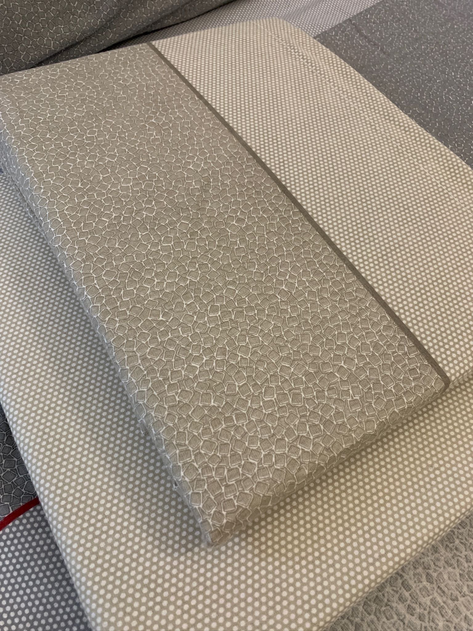 Os lençóis possuem um padrão de mosaicos e uma faixa de bolinhas, oferecendo uma estética elegante e um toque suave devido à flanela de algodão premium. Eles prometem sono de qualidade, durabilidade e um estilo sofisticado, ideal para quem valoriza excepcionalidade em roupa de cama.