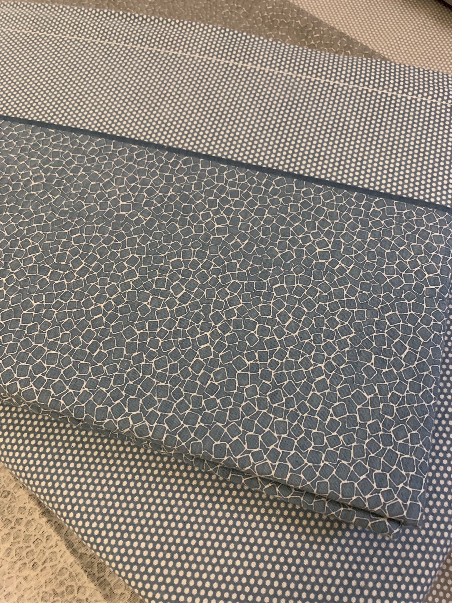 Os lençóis possuem um padrão de mosaicos e uma faixa de bolinhas, oferecendo uma estética elegante e um toque suave devido à flanela de algodão premium. Eles prometem sono de qualidade, durabilidade e um estilo sofisticado, ideal para quem valoriza excepcionalidade em roupa de cama.